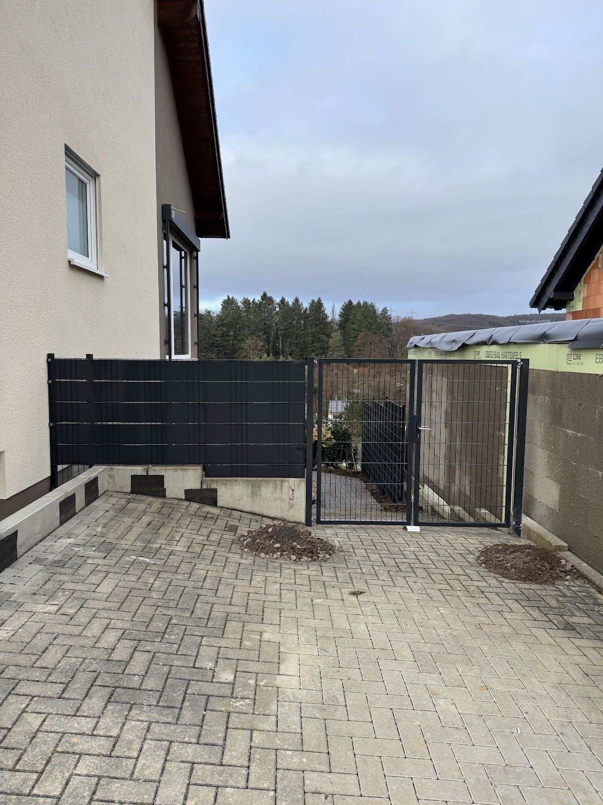 Gepflasterter Hof mit neuem Zauntor — Projekt von BauPlus